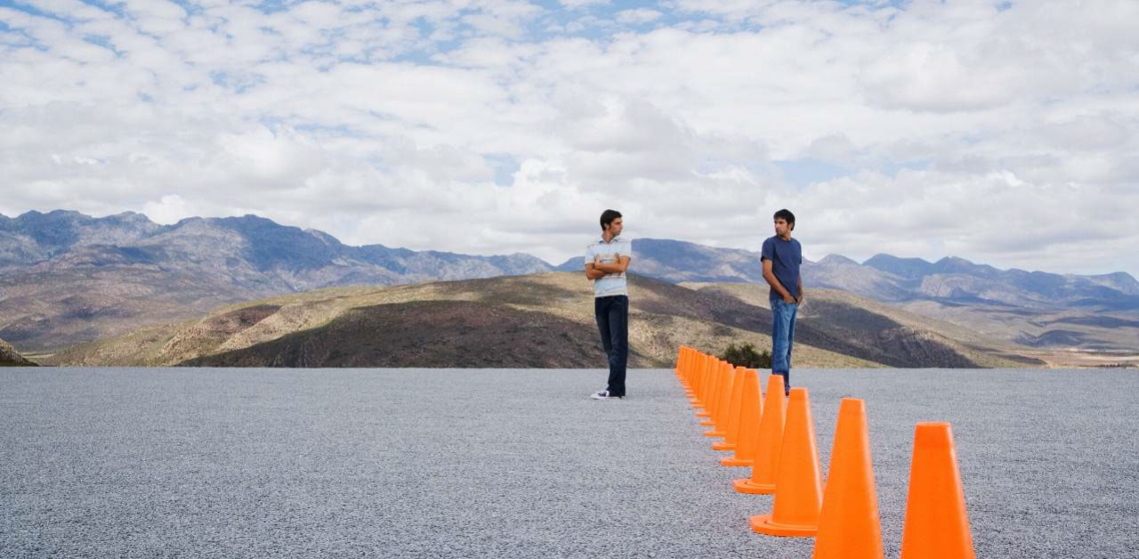 two men separated by orange cones